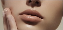 Fingertips resting on smooth cheek skin